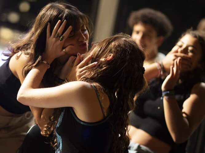 Jongeren spelen theater. Ze dansen en maken plezier in de theaterzaak.